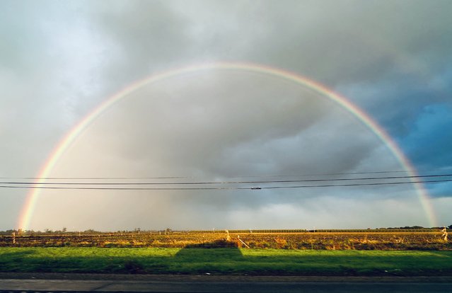 A rainbow is seen above the shadow of a vehicle travelling along Hwy 99 in central California near Galt, California, on October 26, 2025. (Photo by Frederic J. Brown/AFP Photo)