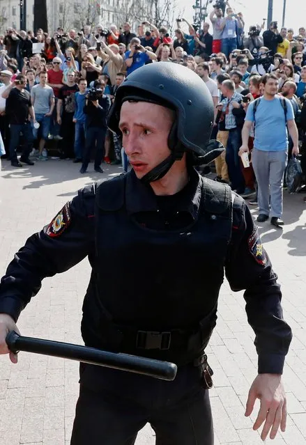 A young Russian riot policeman appears to be concerned upon the tense situation during an unauthorized liberal opposition rally, called by their leader Alexei Navalny, prior to the official inauguration of president Putin, in Moscow, 05 May 2018. Russian opposition activists are continuing their protests against the re-election of president Vladimir Putin in March 2018. (Photo by Sergei Ilnitsky/EPA/EFE)