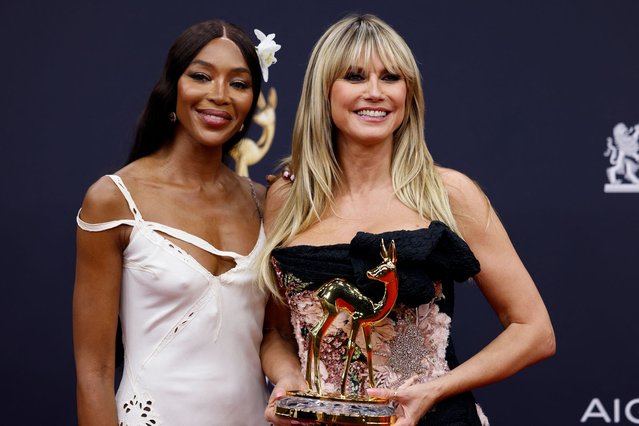 German-American model and TV personality Heidi Klum (right) poses with her Bambi award for promoting diversity next to British supermodel Naomi Campbell during the ceremony for the German media award Bambi in Munich, Bavaria on November 13, 2025. (Photo by Felix Hörhager/dpa)