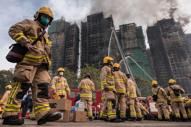 Firemen get ready after a major fire swept through several apartment blocks at the Wang Fuk Court residential estate in Hong Kong's Tai Po district on November 27, 2025. Hong Kong firefighters were scouring a still-burning apartment complex for hundreds of missing people on November 27, a day after the blaze tore through the high-rises, killing at least 44. (Photo by Dale De La Rey/AFP via Getty Images)