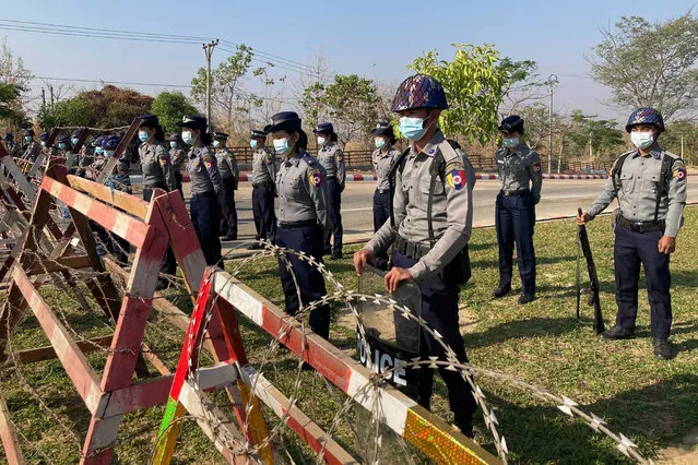 Police stand guard behind a road barricade, part of security preparations ahead of next week's opening of Myanmar's parliament in Naypyitaw, Myanmar Friday, January 29, 2021. Myanmar's election commission rejected allegations by the military that fraud played a significant role in determining the outcome of November's elections, which delivered a landslide victory to Aung San Suu Kyi's ruling party. (Photo by Aung Shine Oo/AP Photo)