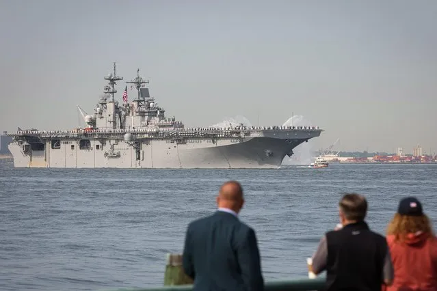 People watch as Sailors and Marines line the deck of the USS Wasp, an amphibious assault ship, as it arrives in New York Harbor during the parade of ships to kick off “Fleet Week 2023” in New York City, U.S., May 24, 2023. (Photo by Brendan McDermid/Reuters)