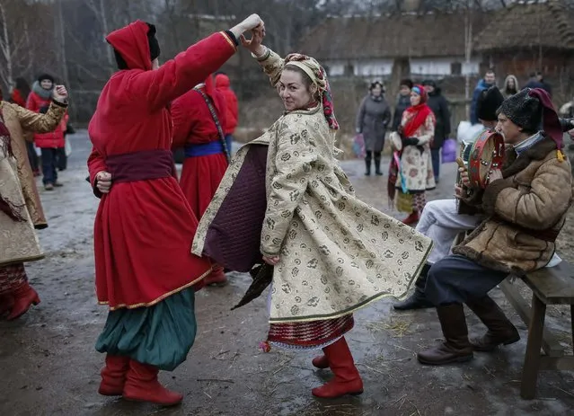 Ukrainians dressed in traditional costumes dance during Orthodox Epiphany celebrations in Kiev January 19, 2015. (Photo by Gleb Garanich/Reuters)