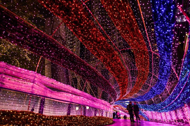 Visitors walk at a Christmas light tunnel during the 2024 New Taipei Christmasland on Christmas eve in New Taipei City on December 24, 2024. (Photo by I-Hwa Cheng/AFP Photo)