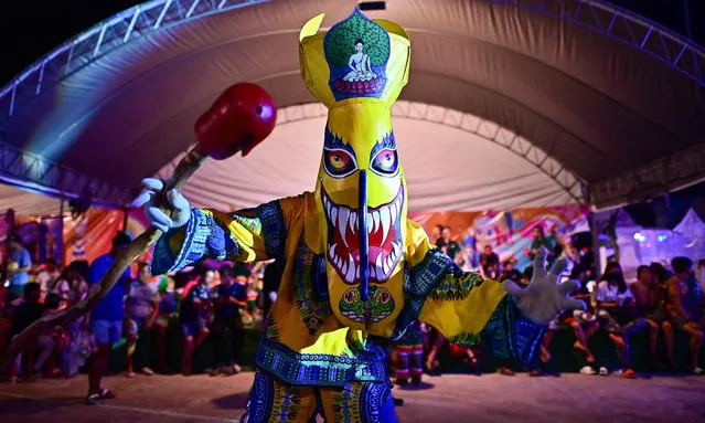 This photo taken on June 23, 2023 shows festival-goers wearing ghost masks and colorful costumes while dancing at night during the annual Phi Ta Khon carnival or ghost festival in Dan Sai district in northeastern Thailand’s Loei Province. (Photo by Manan Vatsyayana/AFP Photo)