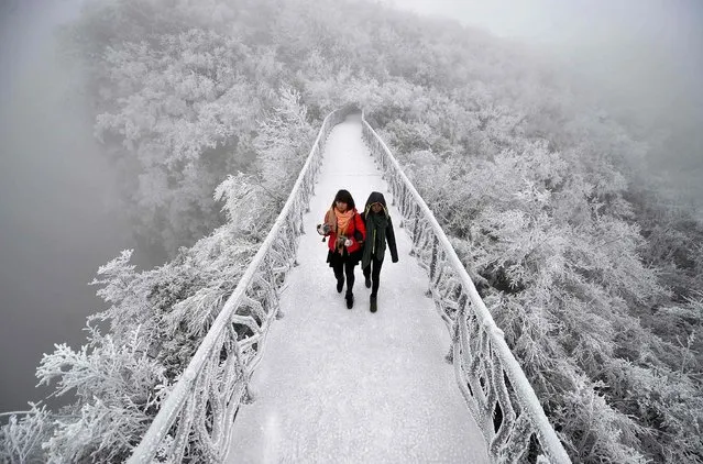 Tourists walk on a bridge covered by frosty fog on the Tianmen Mountain resort in Zhangjiajie, Hunan province, January 29, 2015. (Photo by Reuters/Stringer)