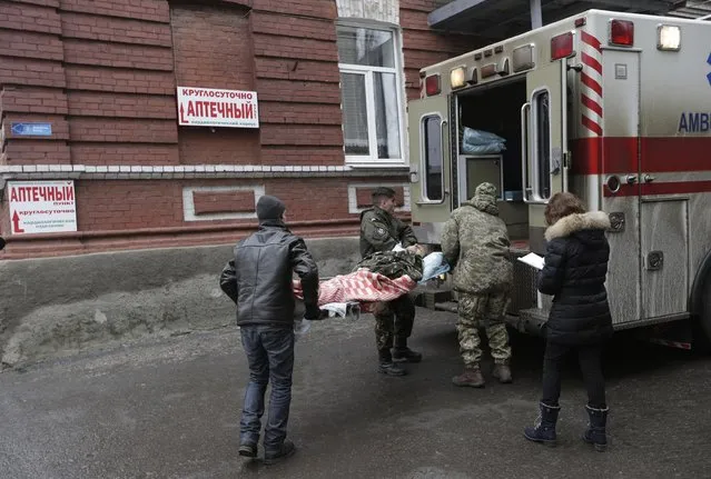 An injured soldier is loaded onto an ambulance outside of a hospital in the town of Artemivsk, Ukraine, Friday, January 30, 2015. (Photo by Petr David Josek/AP Photo)