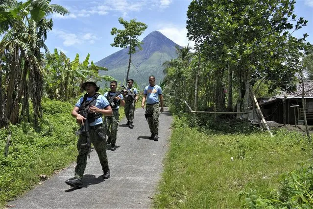 Police conduct an inspection inside the “permanent danger zone” to check for evacuees returning or still staying at their homes at Calbayog village in Malilipot town, Albay province, northeastern Philippines, Thursday, June 15, 2023. (Photo by Aaron Favila/AP Photo)