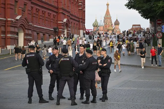 Police officers stand near the Red Square in Moscow, Russia, Tuesday, August 1, 2023. The glittering towers of the Moscow City business district were once symbols of the Russian capital's economic boom in the early 2000s. Now they are a sign of its vulnerability, following a series of drone attacks that rattled some Muscovites shaken and brought the war in Ukraine home to the seat of Russian power. (Photo by Dmitry Serebryakov/AP Photo)