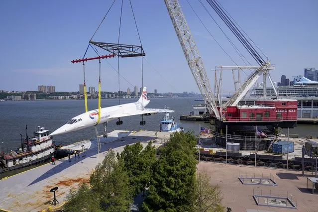 A crane lifts the British Airways Concorde is lifted off the Intrepid Sea, Air & Space Museum onto a barge, Wednesday, August 9, 2023, in New York. The Concorde supersonic jet that has been parked along Manhattan's west side since retiring from commercial air travel took a slow boat to Brooklyn on Wednesday for a facelift that will take several months. (Photo by Mary Altaffer/AP Photo)