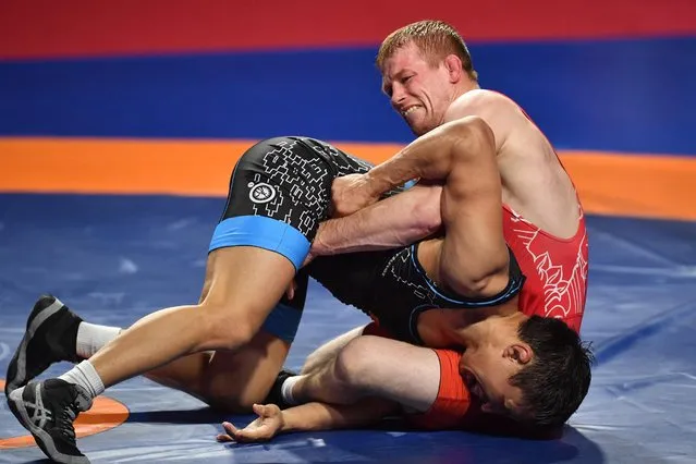 Krzysztof Bienkowski of Poland (red) and Andrei Bekreneu of Belarus in action during the men's -65 kg category at the European Wrestling Championships in Warsaw, Poland, 19 April 2021. (Photo by Radek Pietruszka/EPA/EFE)