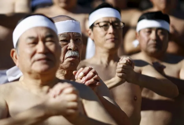 Men wearing the traditional "fundoshi" or loincloth warm up before bathing in ice-cold water at the Teppozu Inari shrine in Tokyo, Japan, January 10, 2016. (Photo by Yuya Shino/Reuters)