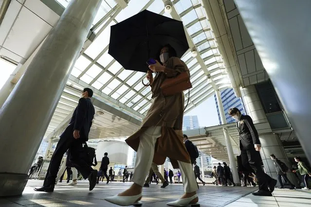 Commuters wearing face masks walk in a passageway during a rush hour at Shinagawa Station Monday, April 26, 2021, in Tokyo. Japan declared a third state of emergency for Tokyo and three western prefectures from Sunday amid skepticism it will be enough to curb a rapid coronavirus resurgence just three months ahead of the Olympics. (Photo by Eugene Hoshiko/AP Photo)
