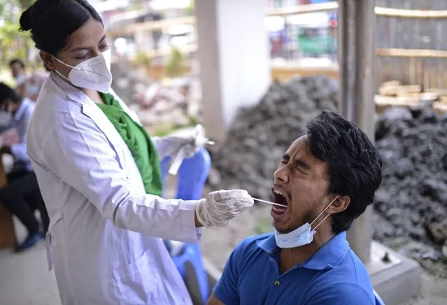 A Bangladeshi health worker takes a mouth swab sample of a man to test for COVID-19 in Dhaka, Bangladesh, Saturday, May 8, 2021. (Photo by Mahmud Hossain Opu/AP Photo)