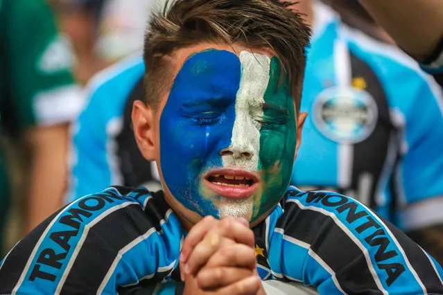 Fans of Gremio react during an homage for the Brazilian team Chapecoense Real victims of a plane crash in Colombia on November 29, ahead of the match between Atletico Mineiro and Gremio for the Copa do Brasil 2016 final at Mineirao stadium in Porto Alegre, Brazil, on December 7, 2016. (Photo by Jefferson Bernardes/AFP Photo)