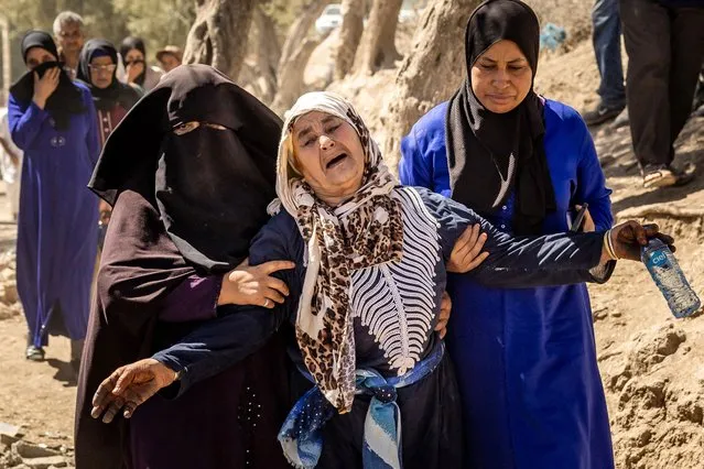 A woman is helped as she reacts to the death of relatives in an earthquake in the mountain village of Tafeghaghte, southwest of Marrakesh, on September 10, 2023. (Photo by Fadel Senna/AFP Photo)