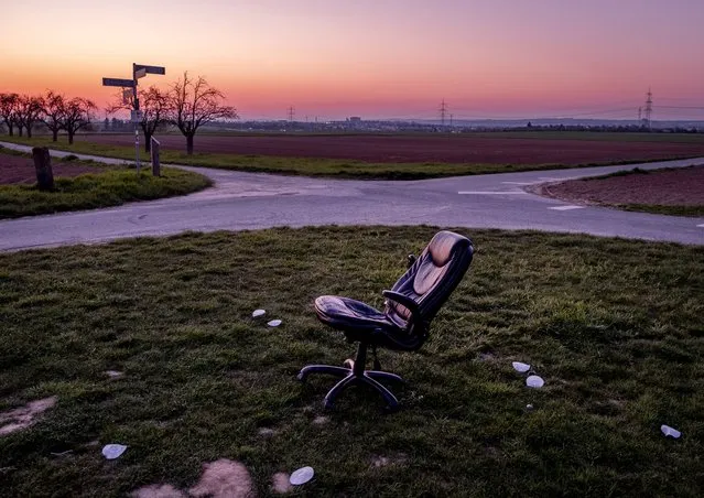 An office chair stands between small roads, fields and acres in the outskirts of Frankfurt, Germany, Wednesday, April 28, 2021. (Photo by Michael Probst/AP Photo)