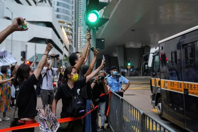 Supporters gesture towards a prison van outside the West Kowloon Magistrates’ Courts, after the court hearing of pro-democracy activists over charges related to the national security law, in Hong Kong, China on May 31, 2021. (Photo by Lam Yik/Reuters)