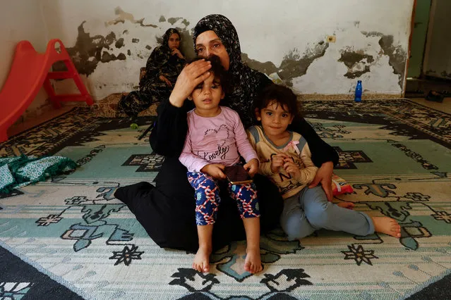 Palestinian woman Samah Abu Latifa, who fled her home amid Israeli strikes, shelters with her family in a kindergarten, in khan Younis in the southern Gaza Strip on October 10, 2023. (Photo by Ibraheem Abu Mustafa/Reuters)