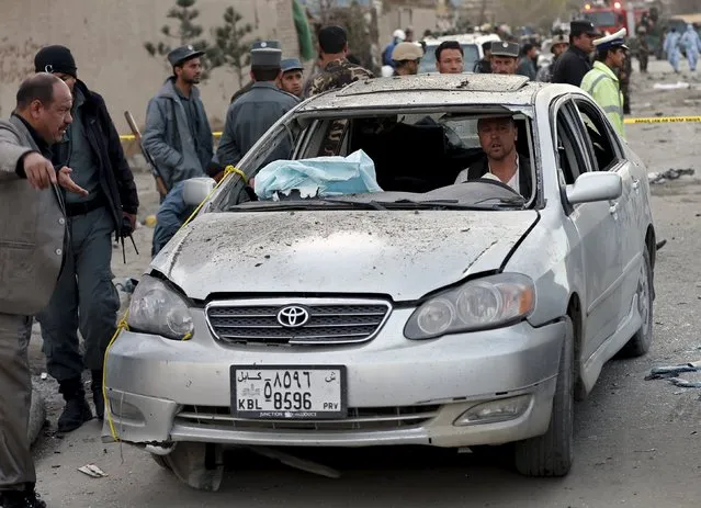 An Afghan man drives his damaged car away from site of a suicide attack in Kabul March 25, 2015. (Photo by Omar Sobhani/Reuters)