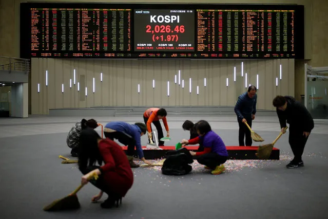 Workers sweep the floor in front of the final stock price index after the ceremonial closing event of the 2016 stock market in Seoul, South Korea, December 29, 2016. (Photo by Kim Hong-Ji/Reuters)