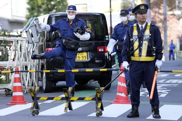 Police officers exam a car, rear, which crashed into a temporary barricade near the Israeli Embassy in Tokyo Thursday, November 16, 2023. Police arrested the driver, according to reports. (Photo by Eugene Hoshiko/AP Photo)