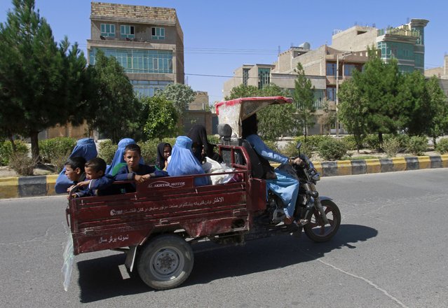 Afghan women and children travel in a motorcycle cart during fighting between Taliban and Afghan security forces in Herat province, west of Kabul, Afghanistan, Sunday, August 1, 2021. (Photo by Hamed Sarfarazi/AP Photo)