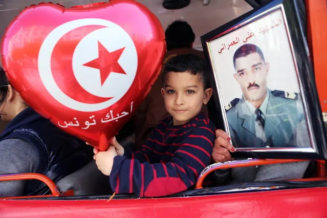 A Tunisian boy holds a balloon reading in Arabic 'I love you Tunisia' during celebrations commemorating Martyrs Day, Tunis, Tunisia, 09 April 2015. Martyrs Day is marked annually 09 April to honor those who took part in wide spread protests 09 April 1938, after a popular leader of the Neo-Destour (New Constitution) Party was arrested, that were suppressed by French policemen killing at least 22 and injuring some 150 others. (Photo by Mohamed Messara/EPA)