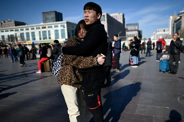 A couple embrace at the entrance to Beijing railway station in the Chinese capital on January 21, 2019, as people begin to head for their hometowns ahead of the Lunar New Year in early February. The world's largest annual migration began on January 21 in China with tens of thousands in the capital boarding trains to journey home for Lunar New Year celebrations. (Photo by Wang Zhao/AFP Photo)