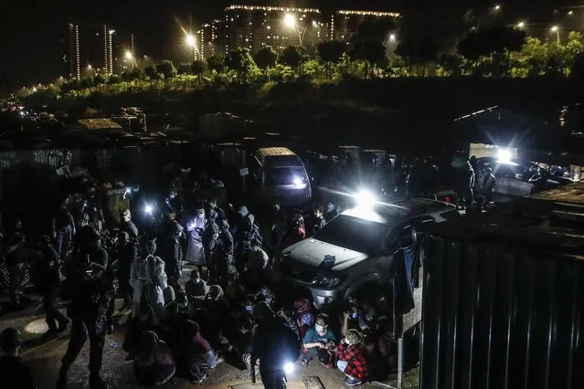 Undocumented immigrants are detained by immigration officers during a raid in Dengkil, outside Kuala Lumpur, Malaysia, 21 June 2021. The Malaysian Immigration Department arrested some 309 undocumented immigrants from various nationalities, such as Indonesians, Bangladeshis, Vietnamese, Indians and Myanmar, during an integrated operation carried out at a settlement near a construction site. (Photo by Fazry Ismail/EPA/EFE)