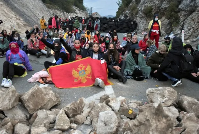 Protesters gather at one of the blockades near Cetinje, Montenegro, Sunday, September 5, 2021. Riot police used tear gas on protesters who fired gunshots in the air and hurled bottles and stones early Sunday in Montenegro before a planned inauguration of the new head of the Serbian Orthodox Church in the country. The ceremony scheduled in Cetinje, a former capital of the small Balkan nation, has angered opponents of the Serbian church in Montenegro, which declared independence from neighboring Serbia in 2006. (Photo by Risto Bozovic/AP Photo)