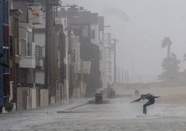Craig Whetter, 14, skim boards during a storm in Seal Beach, Calif., Sunday, January 22, 2017. (Photo by Ana Venegas/The Orange County Register via AP Photo)