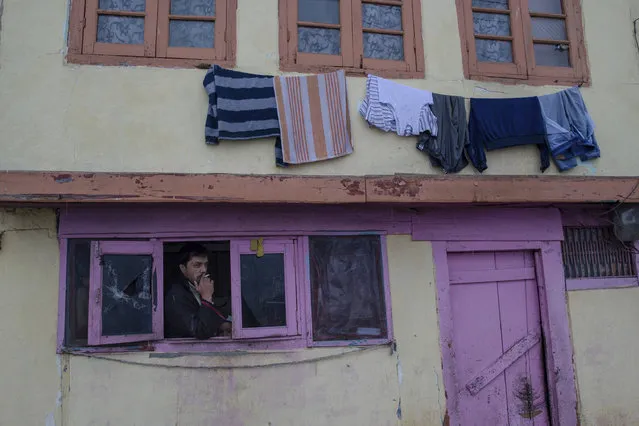 A Kashmir man smokes cigarette as he stands near the window of his house in Srinagar, Indian controlled Kashmir, Wednesday, January 25, 2017. The Kashmir region has been experiencing snow for several consecutive days resulting in the closure of the Srinagar-Jammu highway and suspension of air traffic. (Photo by Dar Yasin/AP Photo)