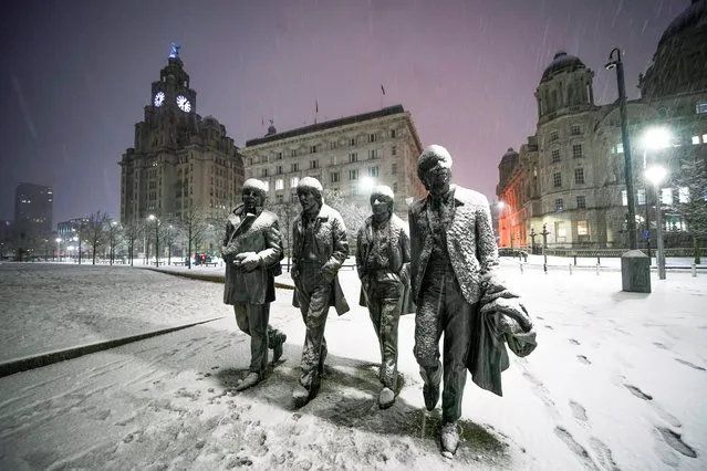 Snow falls on the Beatles Statue at Pier Head, Liverpool on Tuesday, January 16, 2024. Much of Britain is facing another day of cold temperatures and travel disruption after overnight lows dropped below freezing for the bulk of the country. (Photo by Peter Byrne/PA Images via Getty Images)