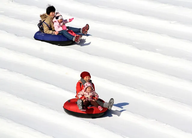 People on a tube ride a slide covered with snow during the Ice and Snow carnival at Taoranting park in Beijing, China, January 30, 2017. (Photo by Reuters/Stringer)