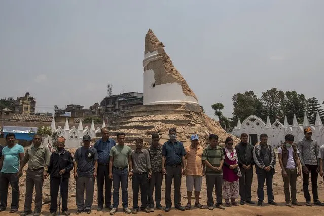 People observe for a minute of silence for victims of the April 25 earthquake, in front of the collapsed Dharhara tower at Kathmandu, in Nepal, May 7, 2015. (Photo by Athit Perawongmetha/Reuters)