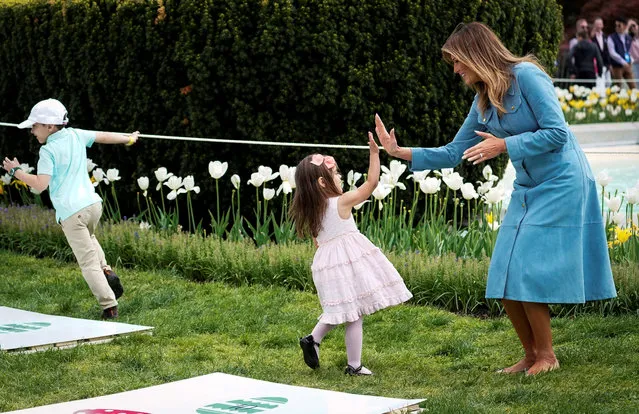 U.S. first lady Melania Trump high fives a child at the hopscotch station during the 2019 White House Easter Egg Roll on the South Lawn of the White House in Washington, U.S., April 22, 2019. (Photo by Al Drago/Reuters)