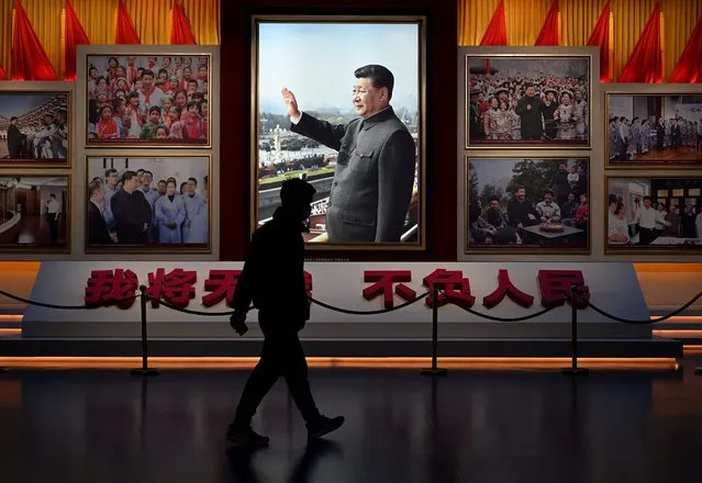 A man walks in front of a picture of China's President Xi Jinping at the Museum of the Communist Party of China in Beijing on November 11, 2021. China's leaders have approved a resolution on the history of the ruling Communist Party that was expected to set the stage for President Xi Jinping to extend his rule next year during a four-day meeting of its Central Committee that ended Thursday. (Photo by Noel Celis/AFP Photo)