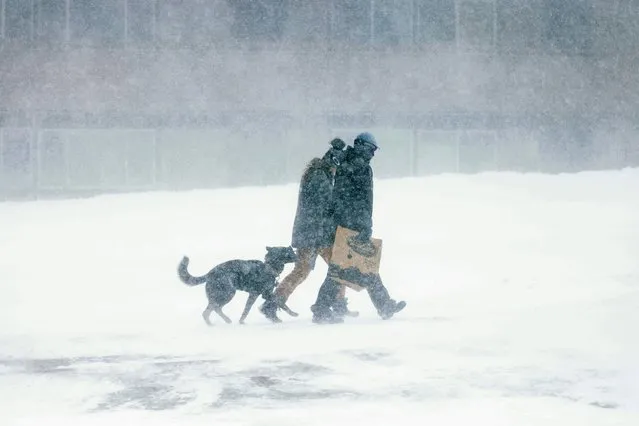 Two people walk with their dog as a blizzard hits Mammoth Lakes closing the mountain for skiers in the Eastern Sierra Nevadas of California, on March 2, 2024. The National Weather Service has issued a blizzard warning for California's entire Sierra Nevada through early March 3, 2024. Forecaster report the storm could bring three to five inches (8 to 13cms) of snow per hour. (Photo by David Swanson/AFP Photo)