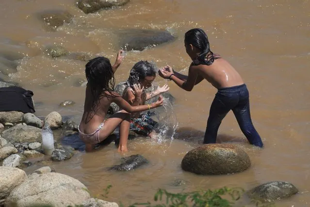 Migrants bathe in the Huixtla River, Chiapas state, Mexico, Tuesday, October 26, 2021, as they take a day of rest before continuing their trek across southern Mexico to the U.S. border. (Photo by Marco Ugarte/AP Photo)