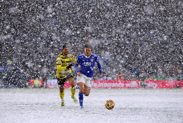 Leicester City's Luke Thomas in action with Watford's Ozan Tufan as snow falls during their Premier League match in Leicester, Britain on November 28, 2021. (Photo by Jason Cairnduff/Action Images via Reuters)