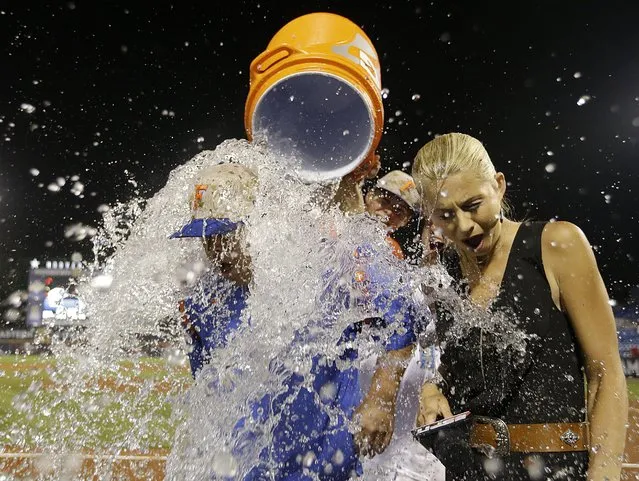 Florida head coach Kevin O'Sullivan and ESPN reporter Laura Rutledge are dunked with water after Florida beat Vanderbilt 7-3 during the Southeastern Conference NCAA college baseball tournament championship game at the Hoover Met, Sunday, May 24, 2015, in Hoover, Ala. (Photo by Butch Dill/AP Photo)