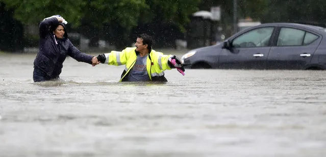 Alberto Lopez, right, helps his wife Glenda wade through floodwaters as they evacuate their flooded apartment complex Monday, April 18, 2016, in Houston. Storms have dumped more than a foot of rain in the Houston area, flooding dozens of neighborhoods and forcing the closure of city offices and the suspension of public transit. (Photo by David J. Phillip/AP Photo)