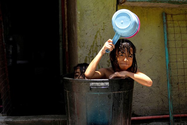 Children take a bath in a bucket during a hot day in Manila, Philippines, on April 25, 2024. (Photo by Eloisa Lopez/Reuters)