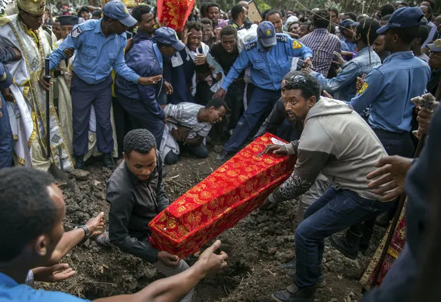 The coffin of one of those killed in the collapse of a mountain of trash at a garbage dump arrives for the burial, at the Gebrekristos church in Addis Ababa, Ethiopia Monday, March 13, 2017. The death toll reached more than 60 on Monday from the collapse at the dump on the outskirts of the capital, according to the state-affiliated Fana Broadcasting Corporate, as relatives waited for news of the dozens of people said to be missing. (Photo by Mulugeta Ayene/AP Photo)