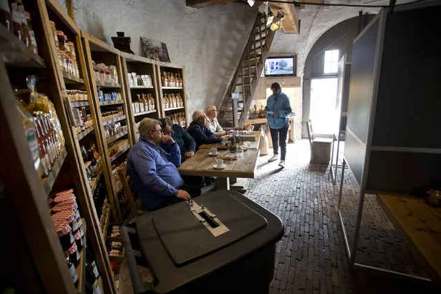 A voter enters the Kerkhovense Molen, a windmill turned polling station in Oisterwijk, south central Netherlands, Wednesday, March 15, 2017. Amid unprecedented international attention, the Dutch go to the polls Wednesday in a parliamentary election that is seen as a bellwether for the future of populism in a year of crucial votes in Europe. (Photo by Peter Dejong/AP Photo)