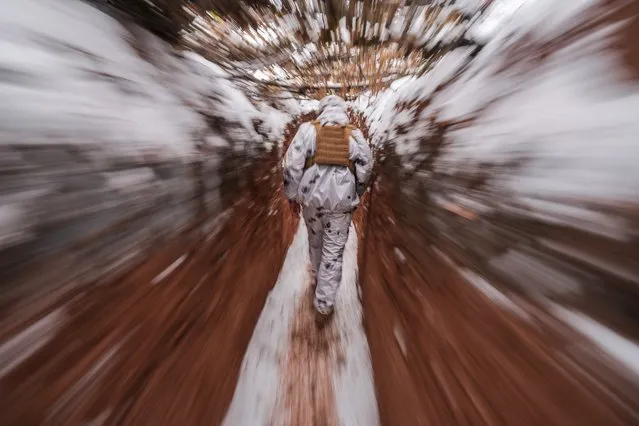 A Ukrainian serviceman walks in a trench at a frontline position in the Donetsk region, eastern Ukraine, Monday, January 31, 2022. The United States and Russia are squaring off at the U.N. Security Council over Ukraine, with Washington calling Moscow's actions a threat to international peace and security, while a Kremlin envoy ridiculed Monday's meeting as a “PR stunt”. (Photo by Vadim Ghirda/AP Photo)