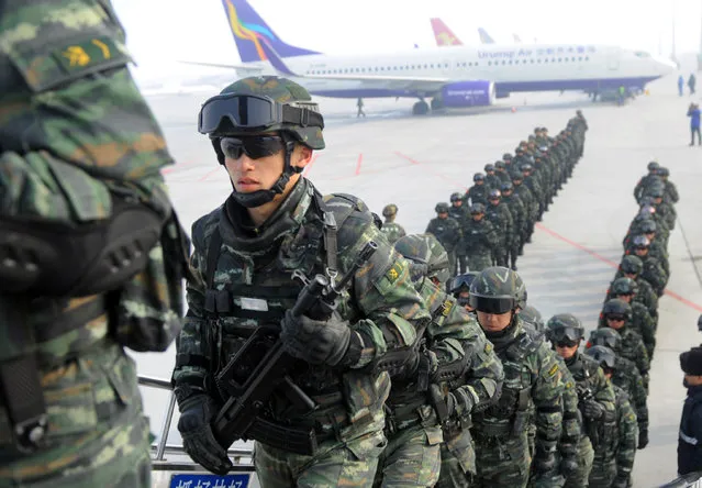 Paramilitary policemen board a plane as they head for an anti-terrorism oath-taking rally in Kashgar, from Urumqi, Xinjiang Uighur Autonomous Region, China, February 27, 2017. (Photo by Reuters/Stringer)