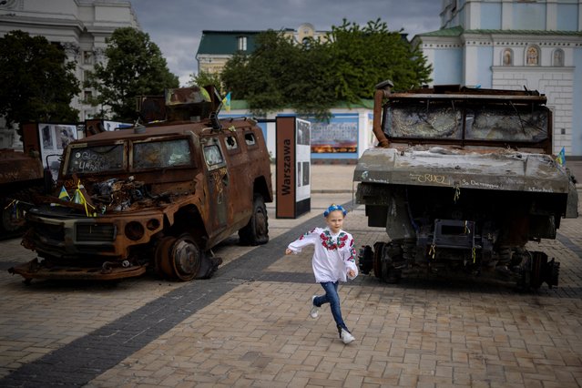 A child, dressed in a vyshyvanka, a traditional Ukrainian embroidered garment, runs between captured Russian armoured vehicles on Vyshyvanka Day, amid Russia's attack on Ukraine, in Kyiv, Ukraine, May 16, 2024. (Photo by Thomas Peter/Reuters)