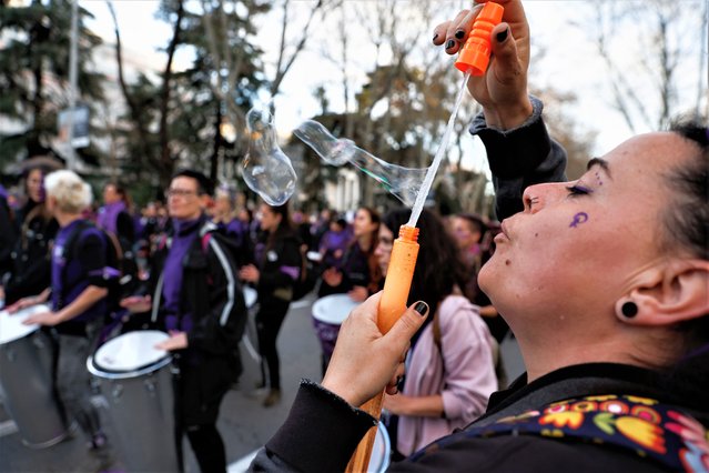 A woman blows soap bubbles during a protest to mark International Women's Day in Madrid, Spain, March 8, 2022. (Photo by Susana Vera/Reuters)